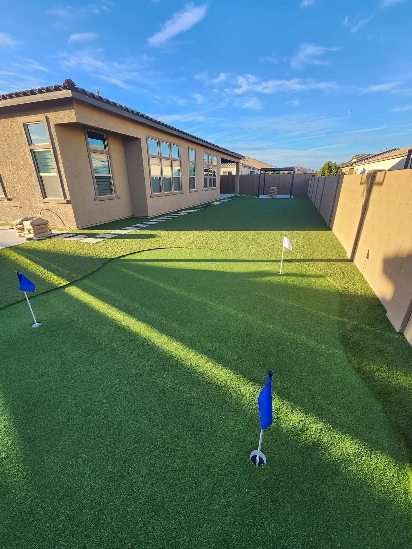A synthetic turf lawn with a putting green in a Peoria backyard