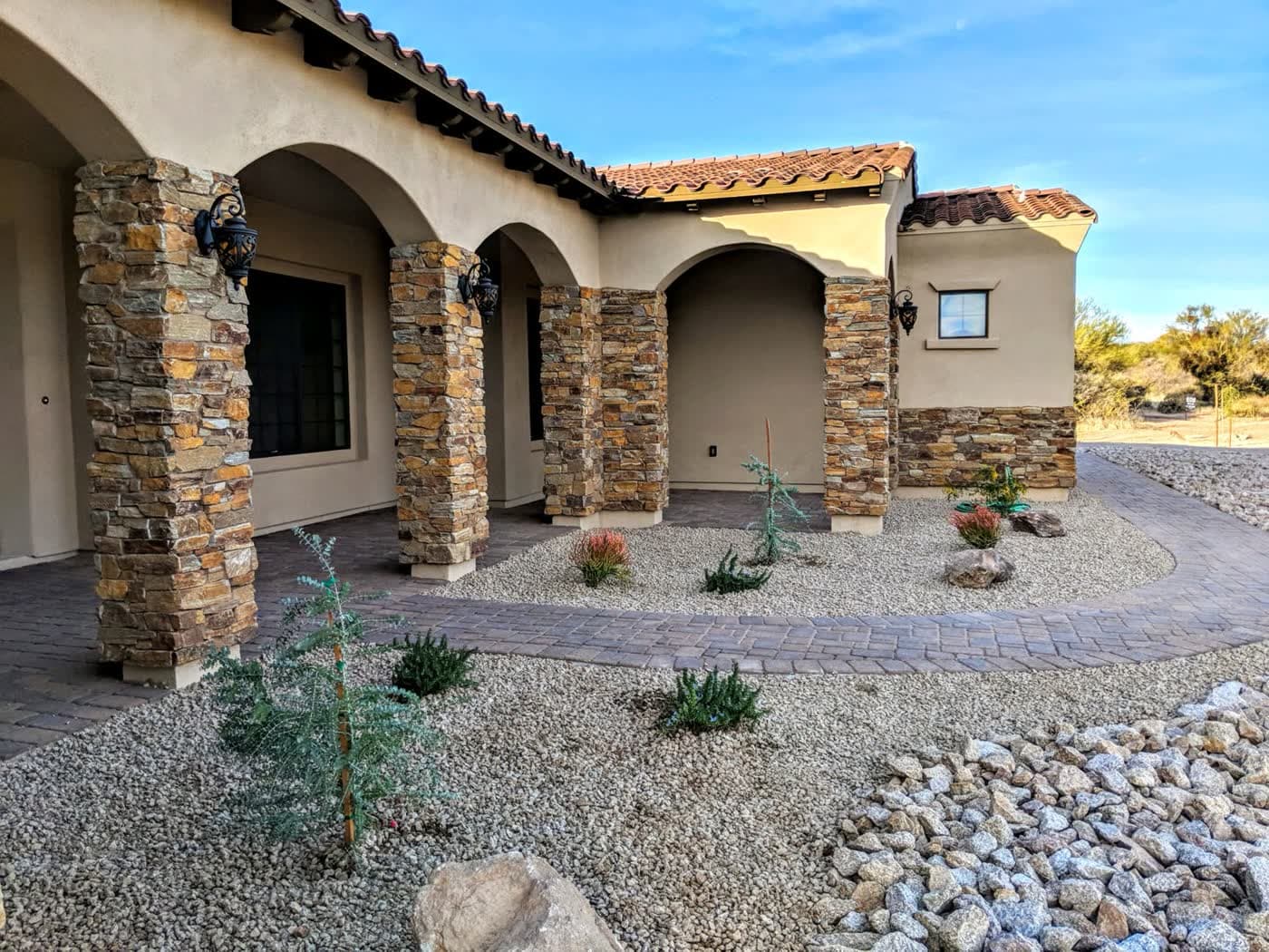 A converted desert front yard with decomposed granite, boulders and drought-adapted planting